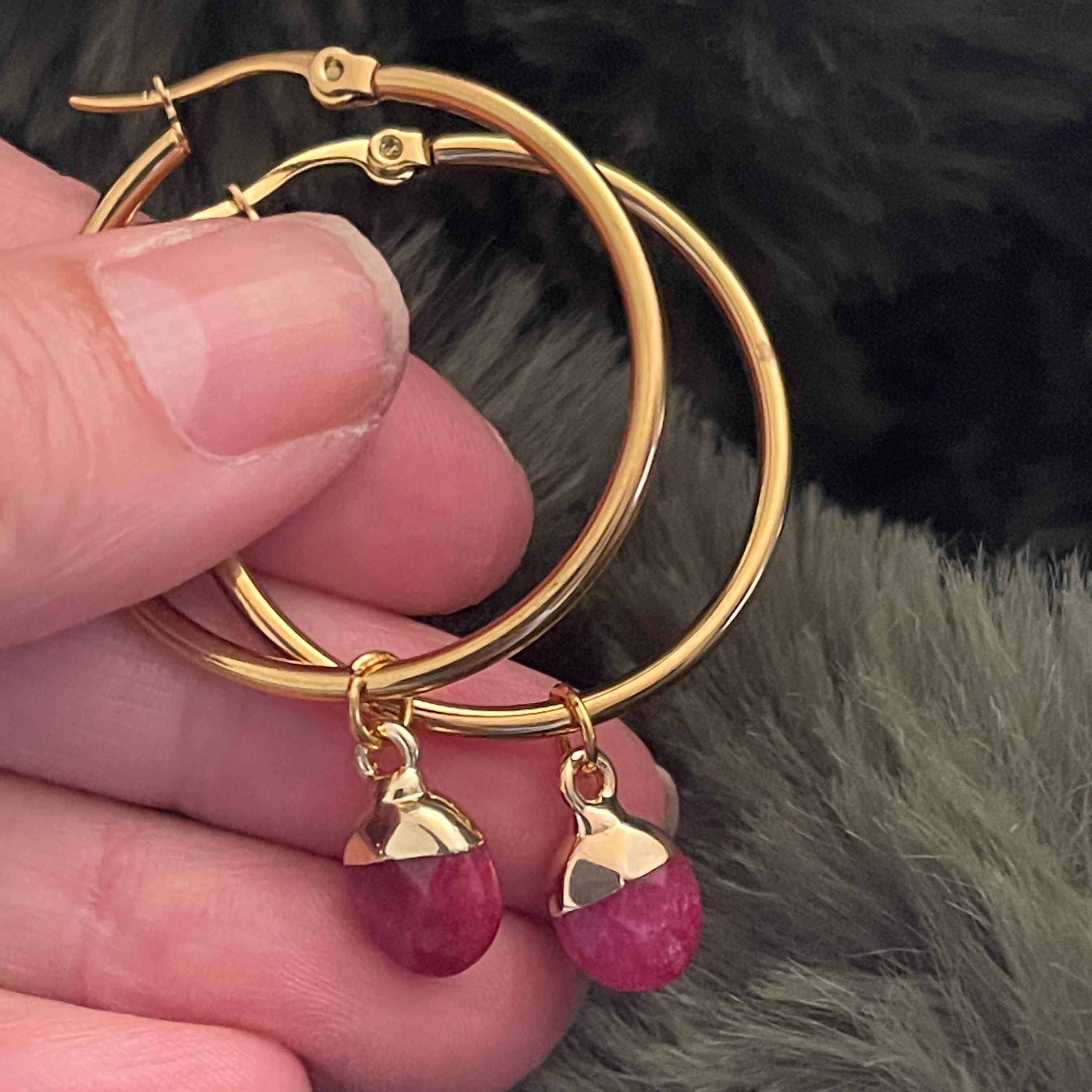 Medium gold hoop earring with a deep pink Quartz crystal.