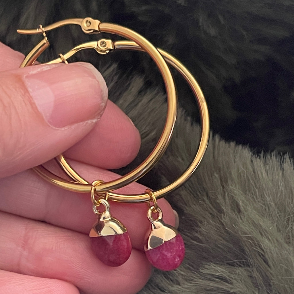 Medium gold hoop earring with a deep pink Quartz crystal.