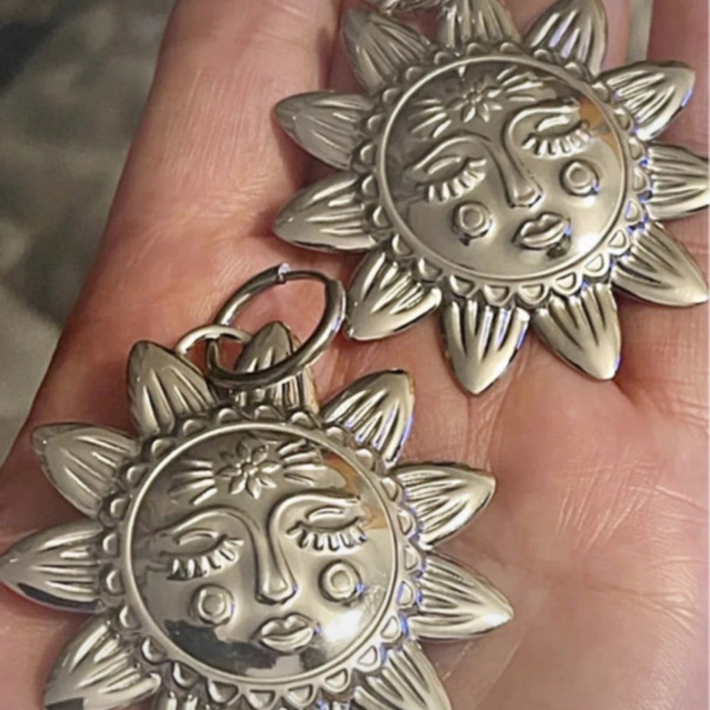 Silver hoop earrings with an X LARGE silver sunbeam with face detail.