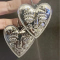 Silver hoop earrings an X LARGE heart with face detail.