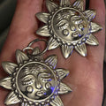 Silver hoop earrings with an X LARGE silver sunbeam with face detail.