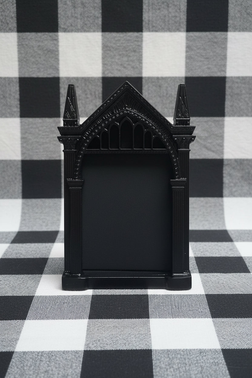 Black decorative item resembling a castle on a checkered fabric background