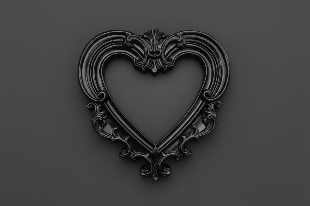 A black ornate heart-shaped decorative frame or picture frame with baroque-style scrollwork, centered on a dark gray background.