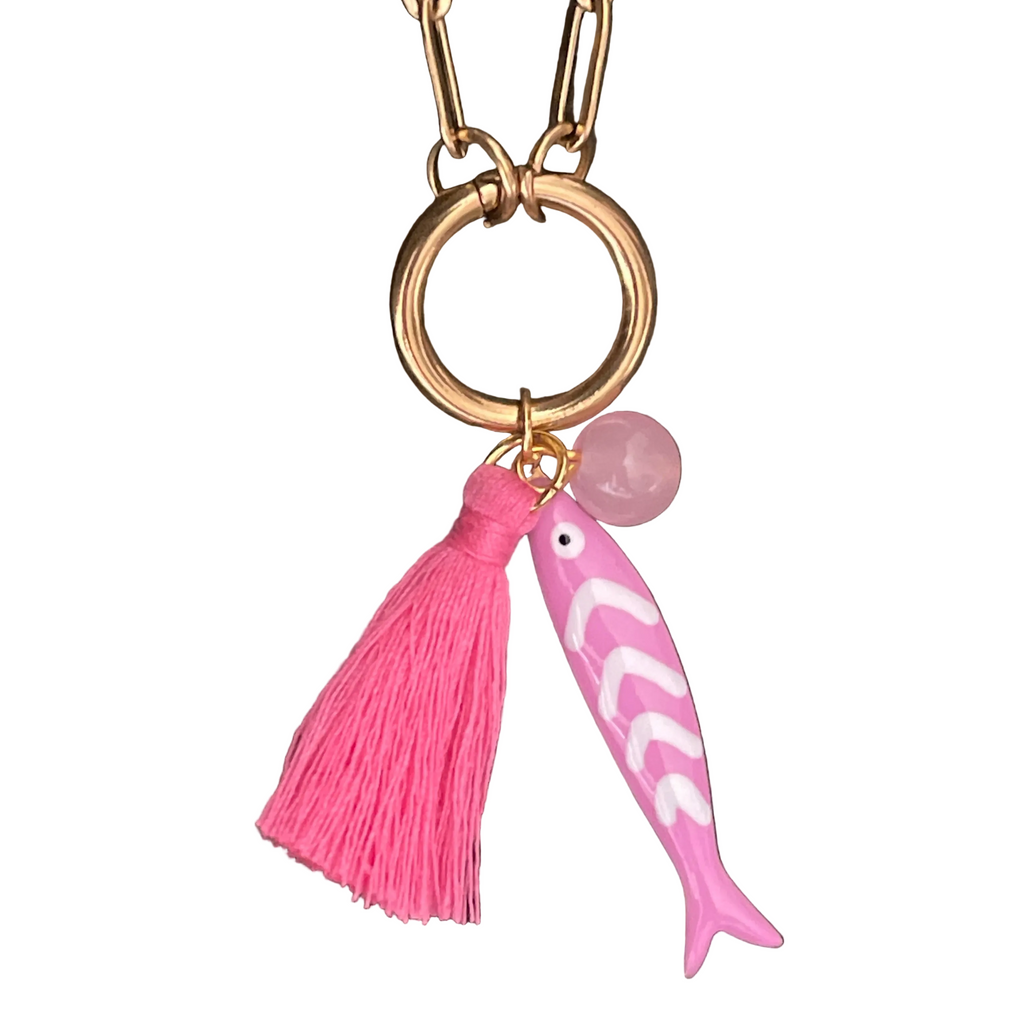 Pink fish and tassel keychain with gold chain on a white background