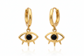 Gold hoop earrings with eye-shaped charms on a white background