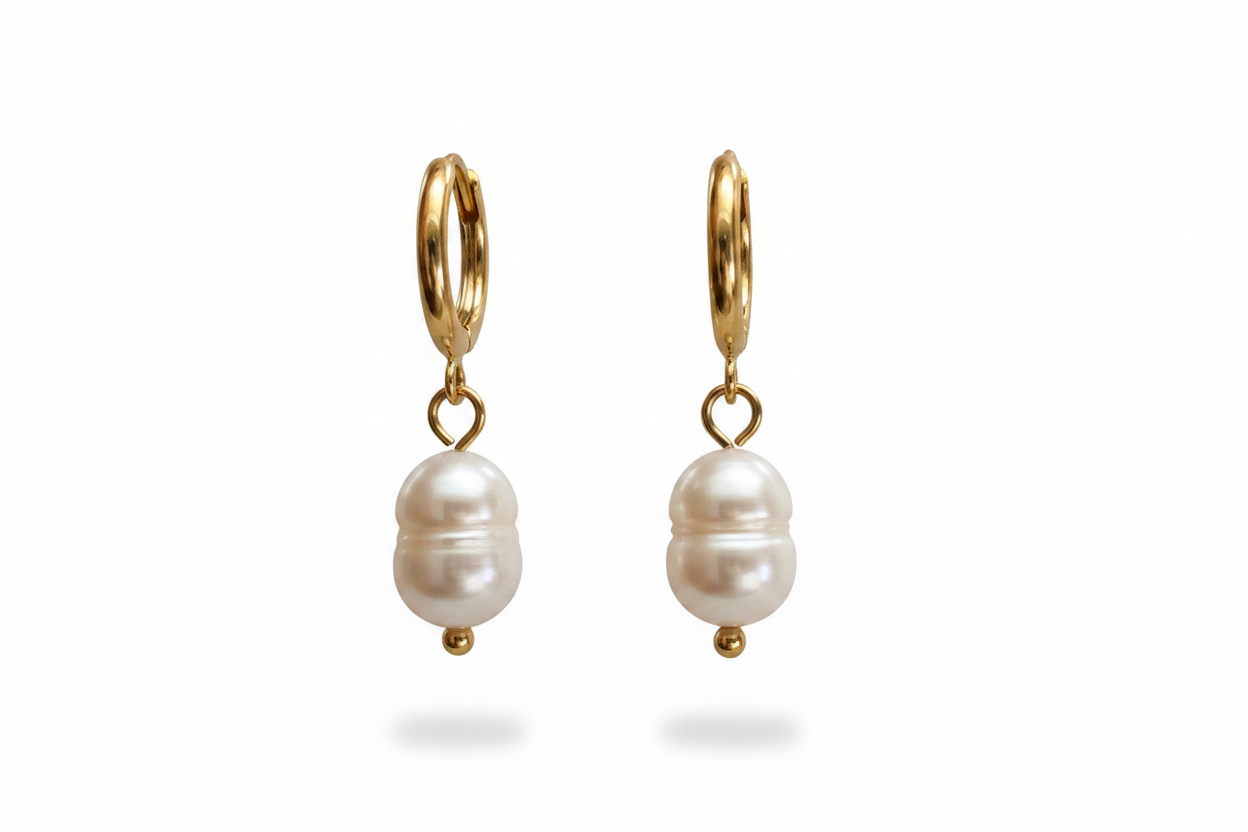 A pair of gold huggie hoop earrings with dangling natural pearl, shown on a clean white background.