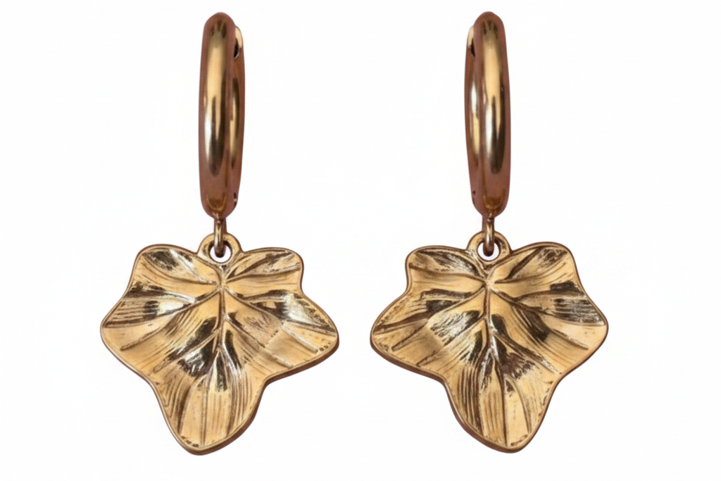 Gold leaf-shaped earrings on a white background