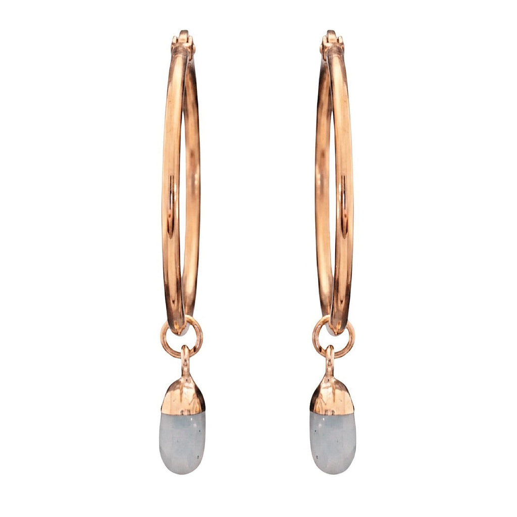 Gold hoop earrings with dangling opal crystals on a white background