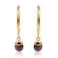 Gold hoop earrings with purple amethyst gemstones on a white background