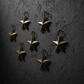 six rusty star-shaped objects against a dark textured background.