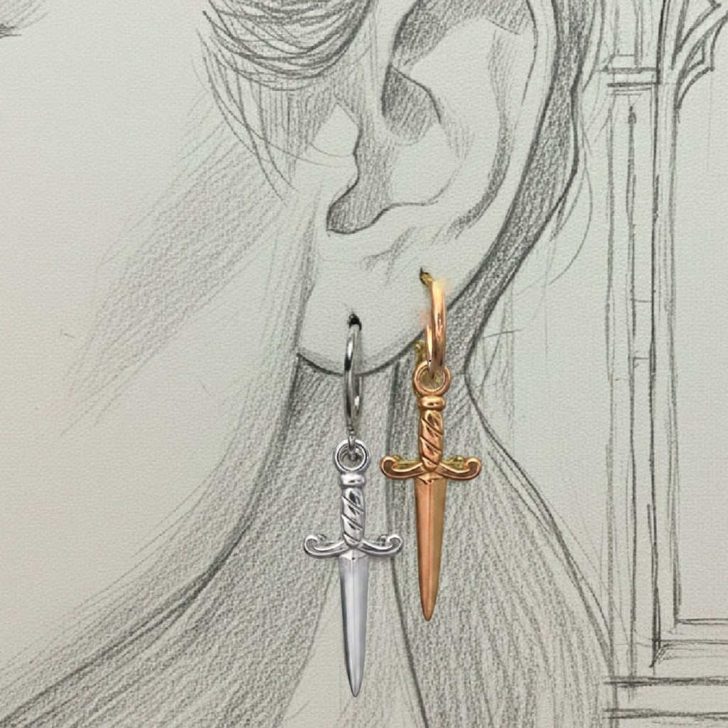 Gold and silver sword-shaped earrings on a pencil-sketch background