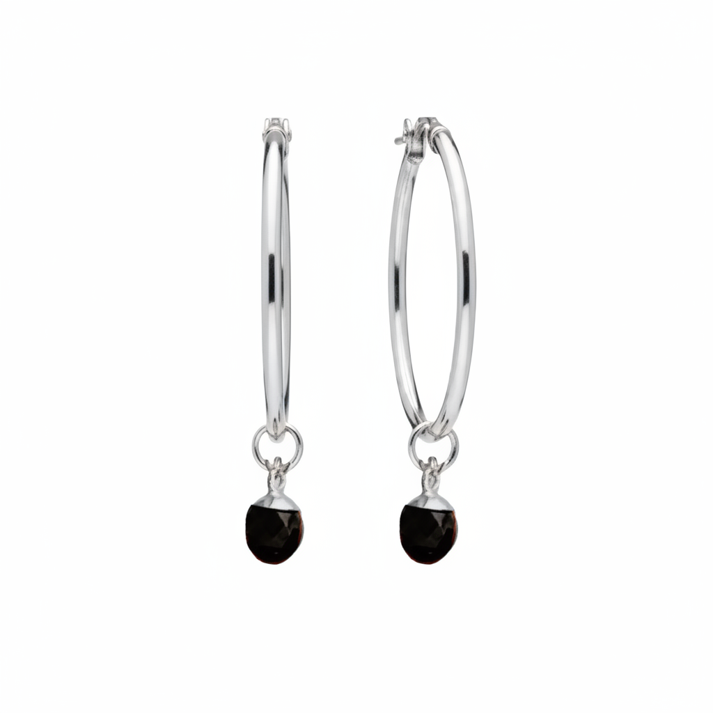 A pair of silver hoop earrings with a small dangling black faceted stone charm, shown against a plain white background.