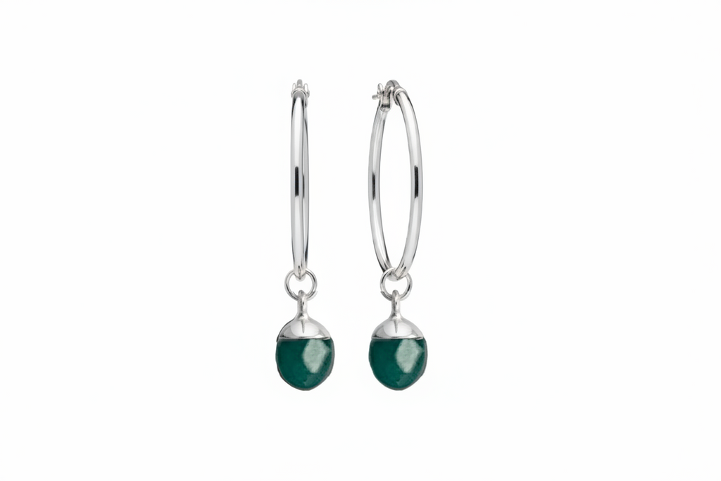 A pair of silver hoop earrings with a turquoise oval crystal against a white background 