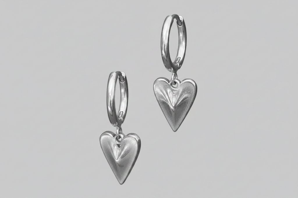 Silver heart-shaped earrings on a gray background