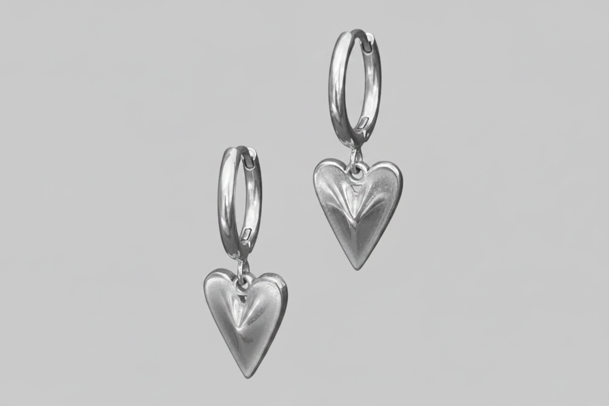Silver heart-shaped earrings on a gray background