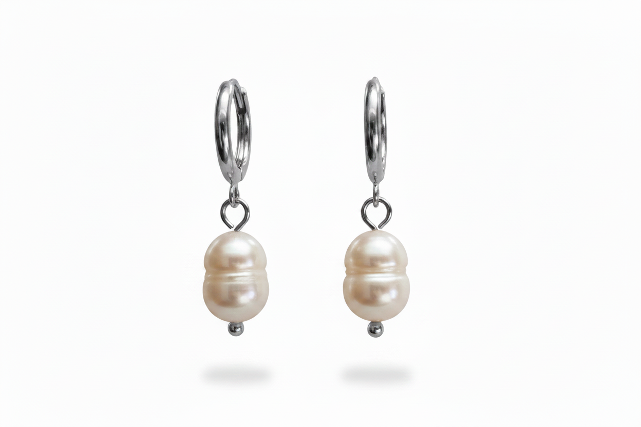 A pair of silver hoop earrings with a natural pearl drop charm, shown against a plain white background.
