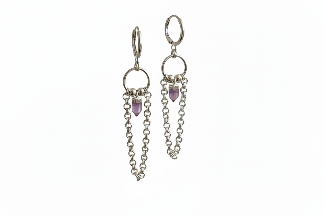 Silver earrings with chain and purple gemstone drops on a white background