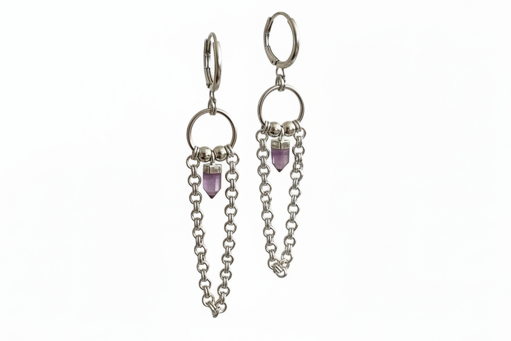 Silver hoop earrings with chainmail detail and an amethyst crystal on a white background.