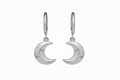 Silver moon-shaped earrings on a white background