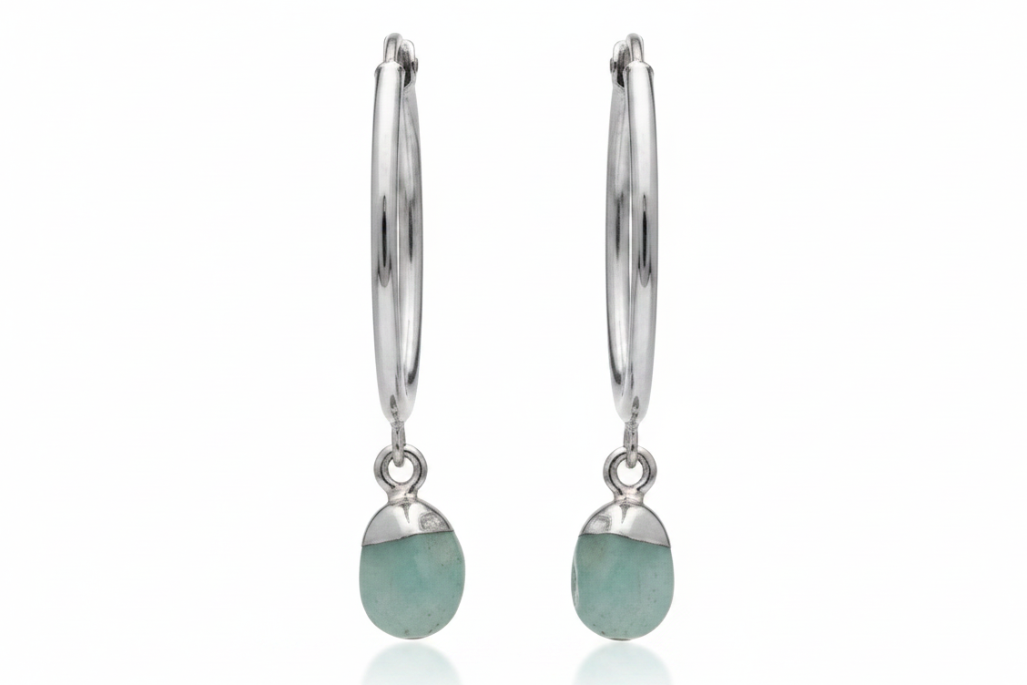 Silver earrings with green gemstones on a white background