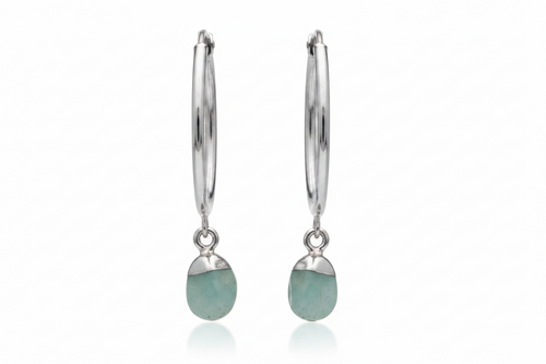 Silver earrings with green gemstones on a white background