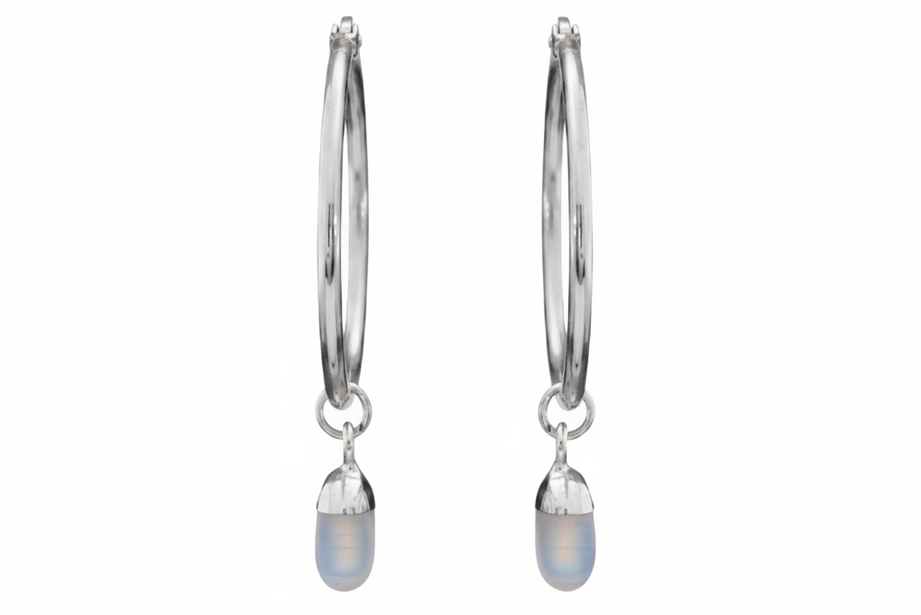 Pair of silver hoop earrings with dangling opal crystals on a white background