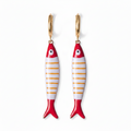 Fish-shaped earrings with red, white, and gold design on a white background